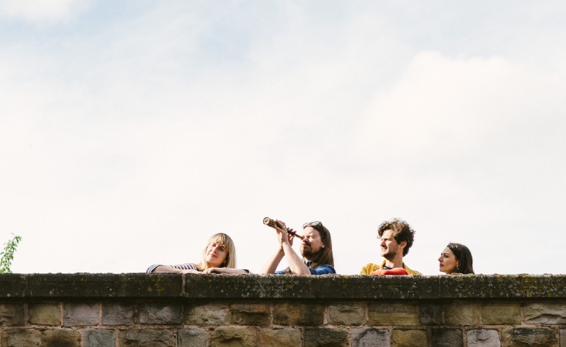 Four people playing Treasure Hunt Bristol looking over a wall 
